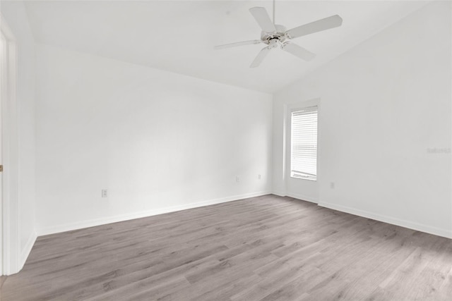 empty room featuring lofted ceiling, ceiling fan, and light wood-type flooring