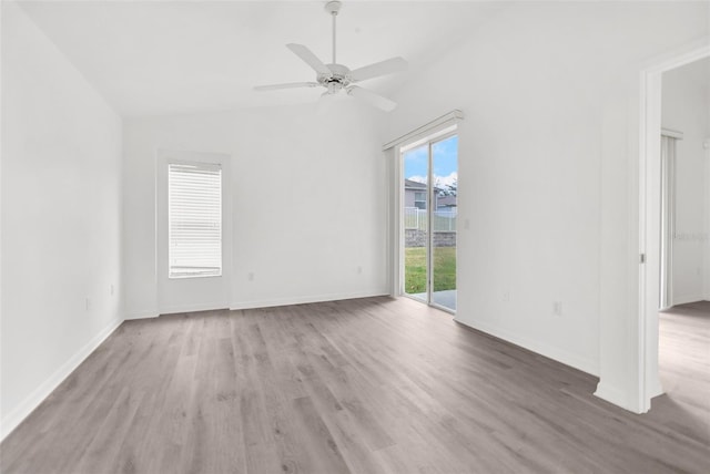 unfurnished room with vaulted ceiling, dark hardwood / wood-style flooring, ceiling fan, and a wealth of natural light