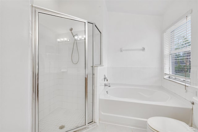 bathroom with tile flooring, toilet, and separate shower and tub