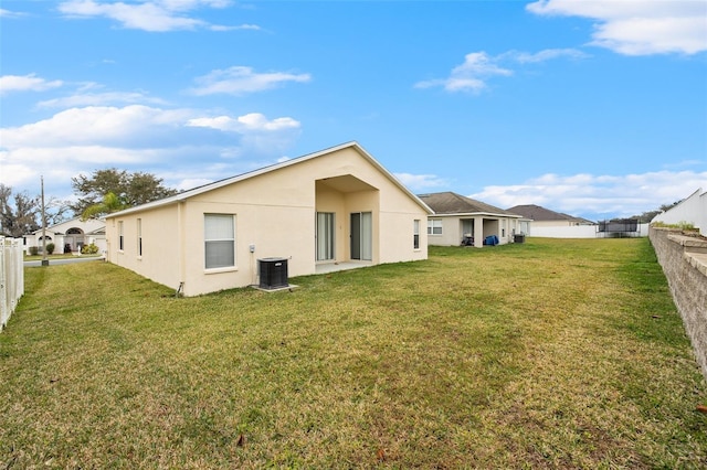 rear view of house with a yard and central air condition unit