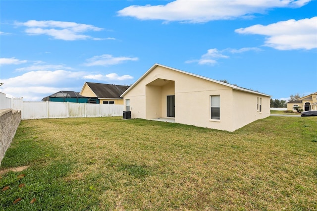 back of house with a lawn and central AC