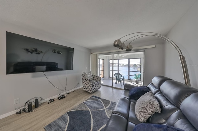 living room with ceiling fan and light wood-type flooring