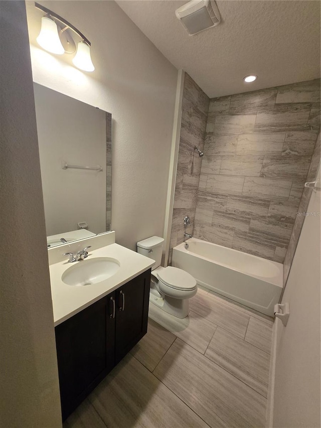 bathroom with vanity, visible vents, a textured ceiling, shower / tub combination, and toilet