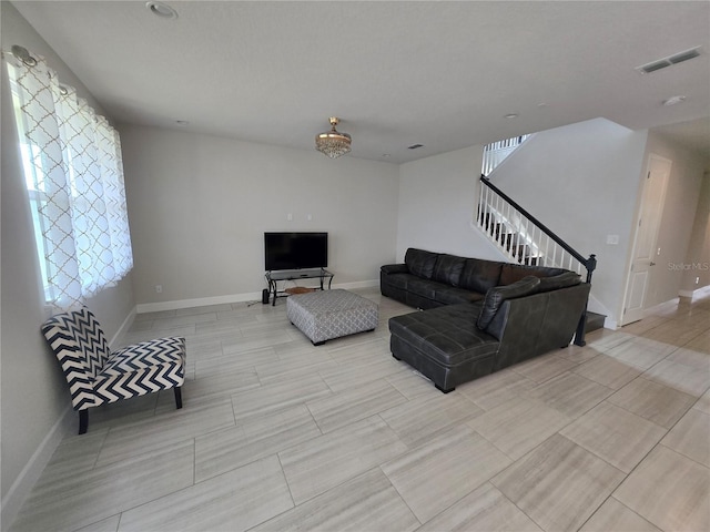 living area with stairs, baseboards, and visible vents