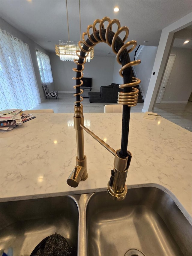 interior details featuring stone counters, baseboards, and a sink