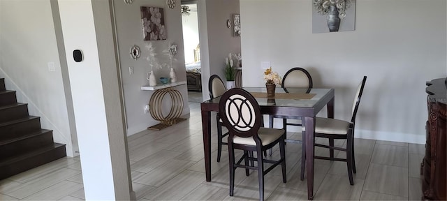 dining room featuring stairway and baseboards