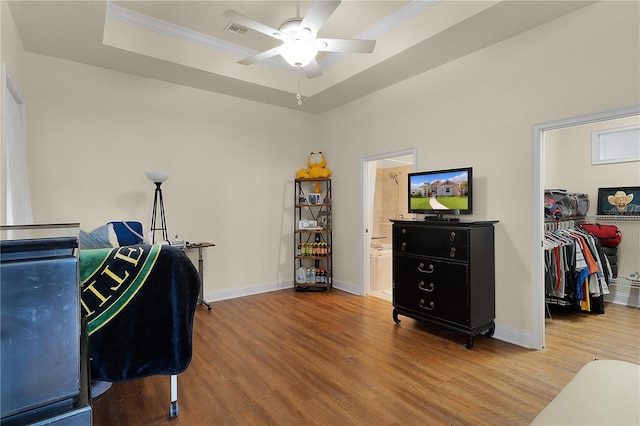 office area featuring light hardwood / wood-style floors, a tray ceiling, and ceiling fan