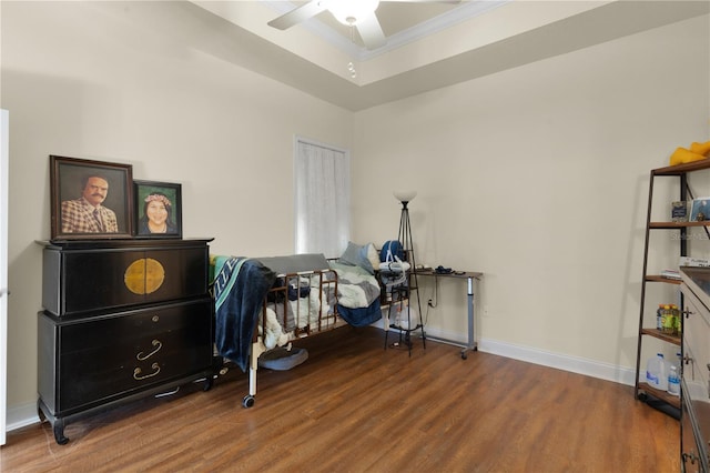 interior space with a tray ceiling, ceiling fan, and wood-type flooring