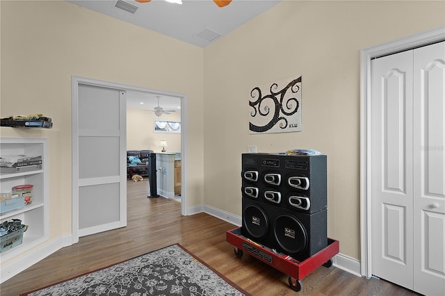 living area with ceiling fan and dark wood-type flooring