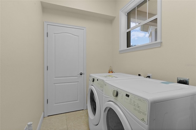 washroom featuring electric dryer hookup, washer and dryer, and light tile floors