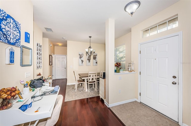 entrance foyer with a notable chandelier and hardwood / wood-style flooring