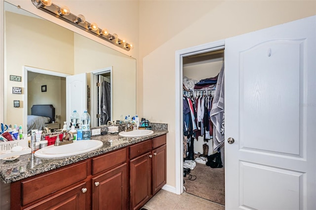 bathroom featuring vanity, lofted ceiling, and tile patterned floors