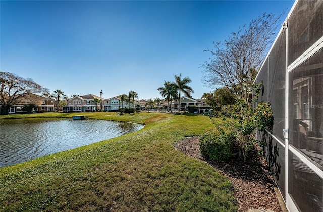 view of yard featuring a water view and glass enclosure