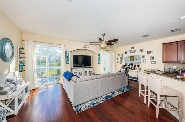 living room with ceiling fan and dark hardwood / wood-style floors