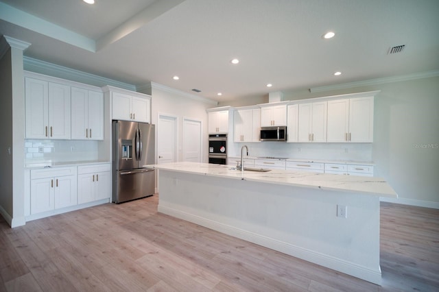 kitchen with an island with sink, white cabinetry, light hardwood / wood-style flooring, and stainless steel appliances