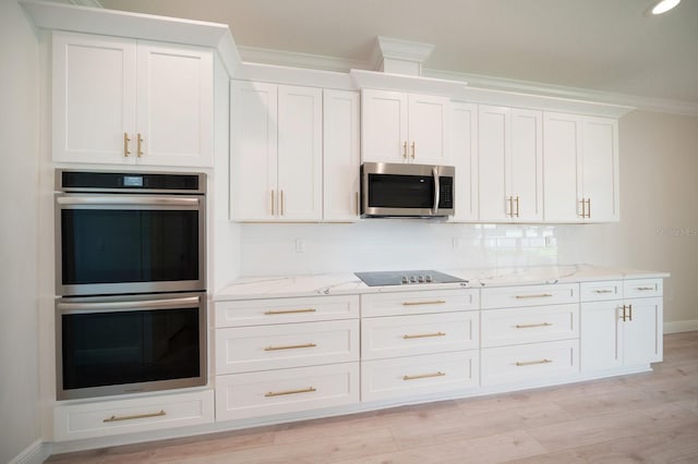 kitchen with crown molding, white cabinets, light hardwood / wood-style floors, stainless steel appliances, and tasteful backsplash