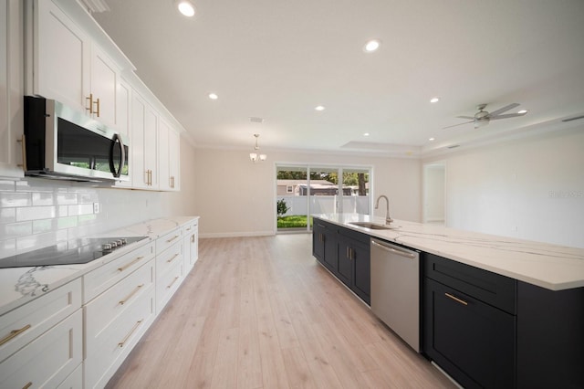 kitchen featuring sink, light hardwood / wood-style floors, stainless steel appliances, tasteful backsplash, and ceiling fan with notable chandelier