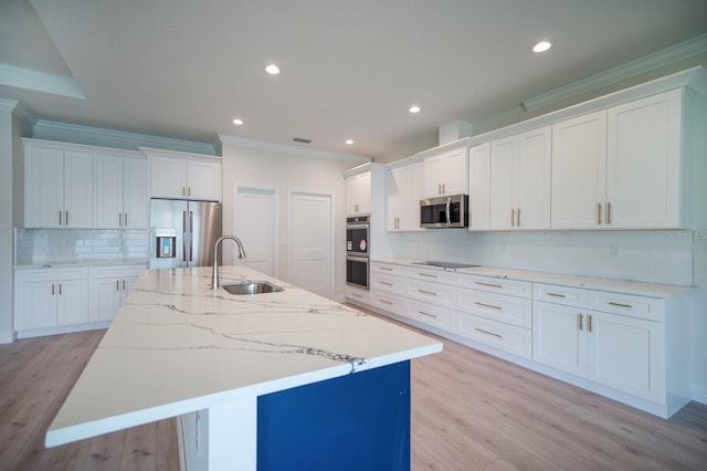 kitchen with backsplash, white cabinets, appliances with stainless steel finishes, and sink