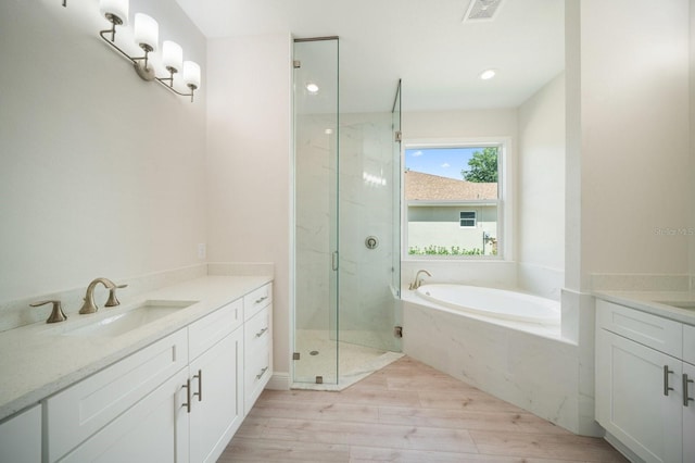 bathroom featuring separate shower and tub, hardwood / wood-style floors, and vanity