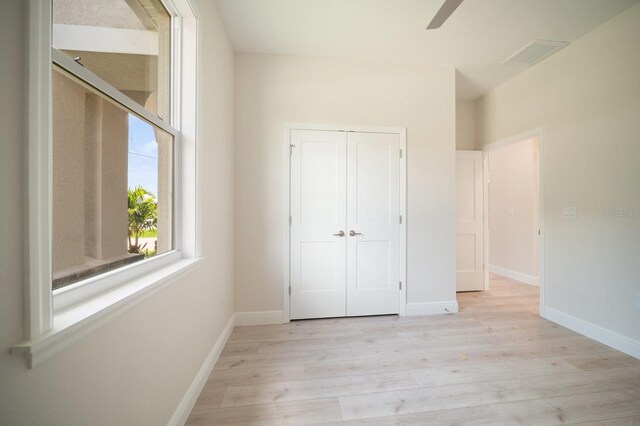 unfurnished bedroom featuring a closet, light hardwood / wood-style floors, and ceiling fan