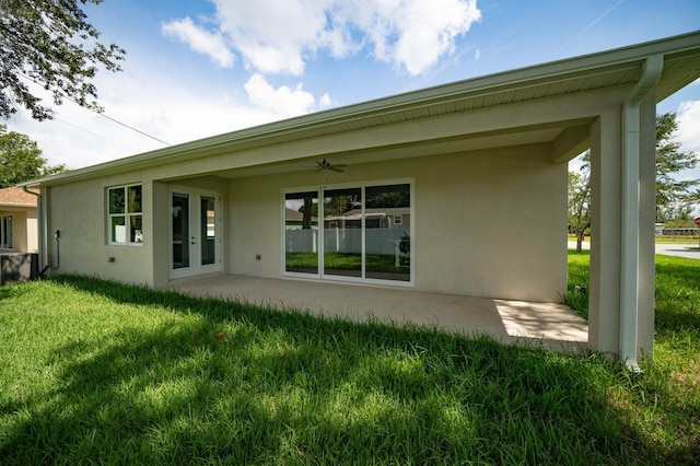 rear view of house with a patio area, french doors, and a yard