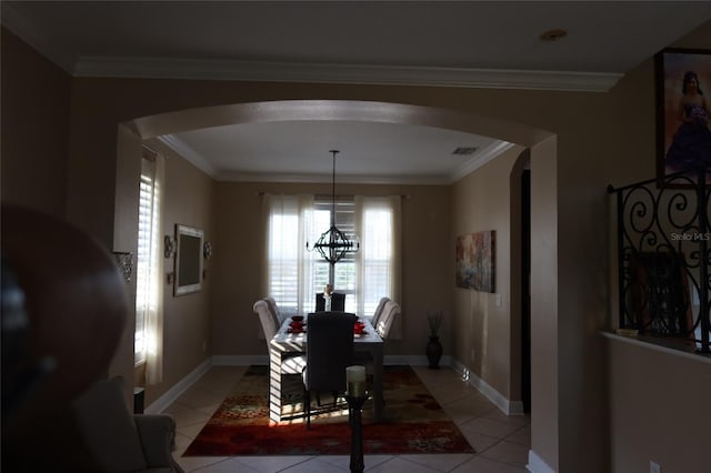 dining room with crown molding, a chandelier, and light tile floors