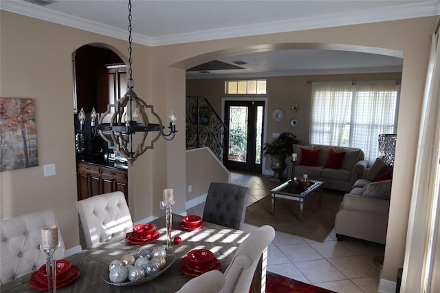 tiled dining room with an inviting chandelier and ornamental molding