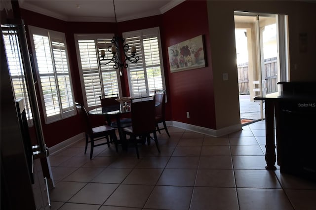 dining space with crown molding, dark tile flooring, french doors, and an inviting chandelier