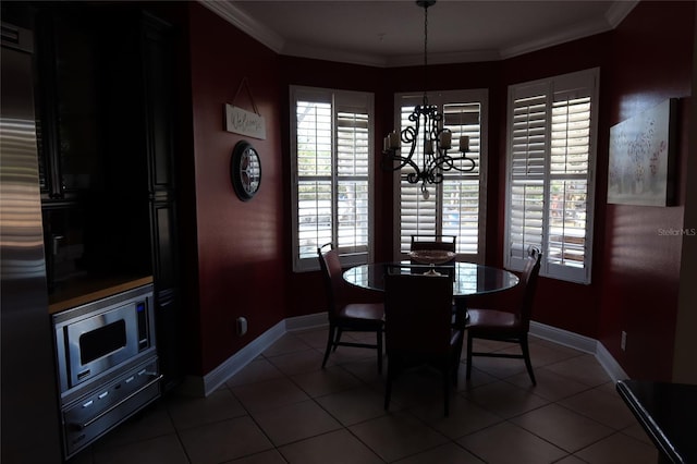 dining space featuring ornamental molding, dark tile floors, and a chandelier