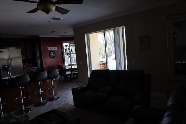 living room with light tile floors, ceiling fan, and ornamental molding