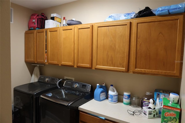 laundry area featuring washing machine and clothes dryer, cabinets, and washer hookup