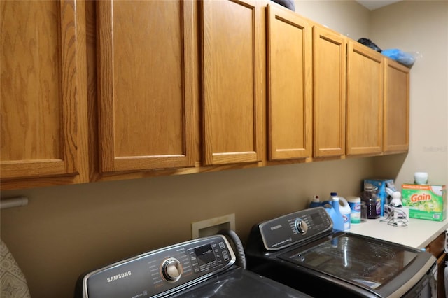 washroom with washer hookup, cabinets, and independent washer and dryer