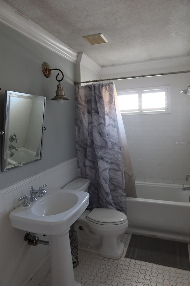 bathroom featuring shower / tub combo, a textured ceiling, toilet, and tile floors