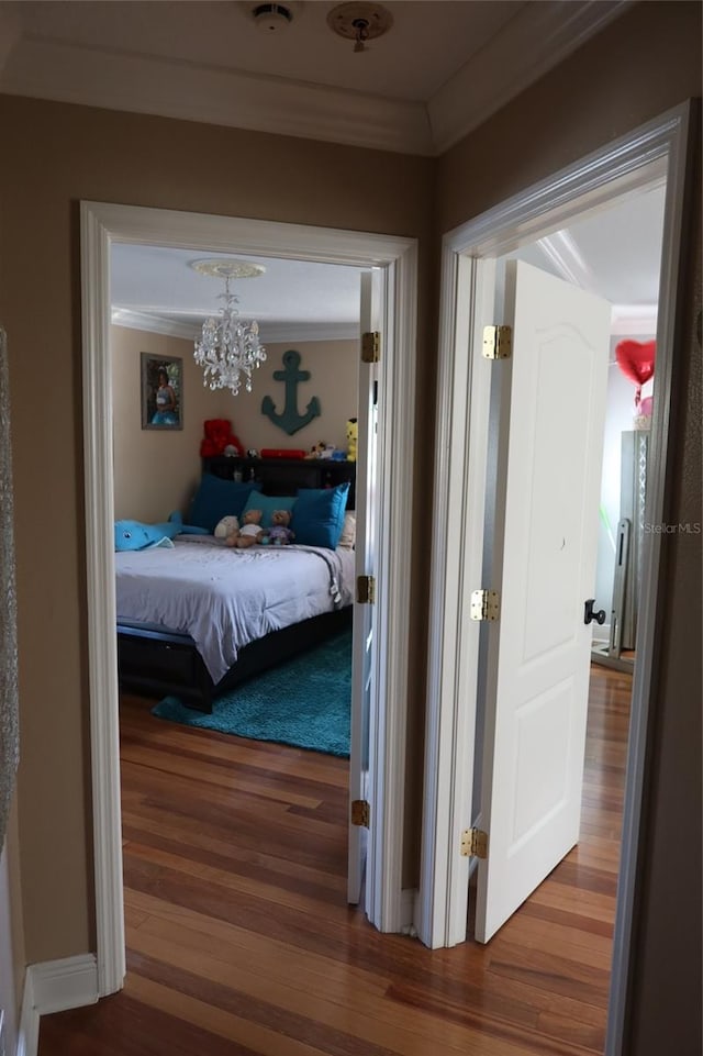 bedroom with crown molding, dark hardwood / wood-style floors, and a chandelier