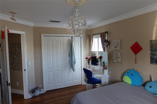 bedroom with dark hardwood / wood-style flooring, a closet, ornamental molding, and a chandelier