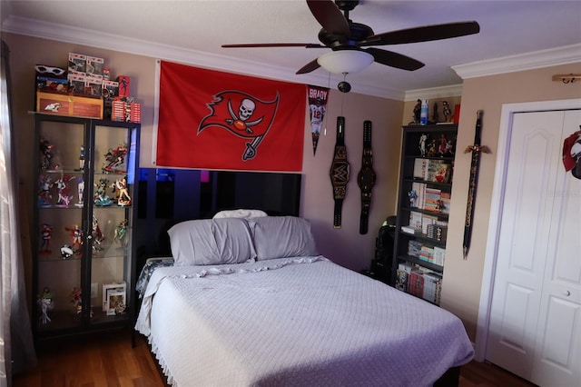 bedroom featuring dark hardwood / wood-style flooring, ceiling fan, a closet, and crown molding