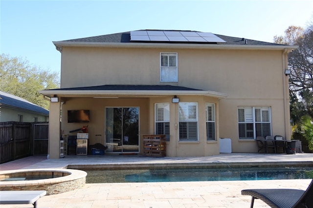 back of property with a patio, a fenced in pool, and solar panels