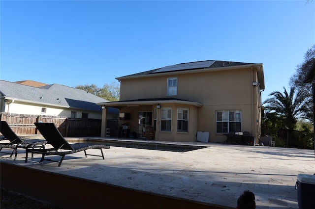 back of house with solar panels and a patio area