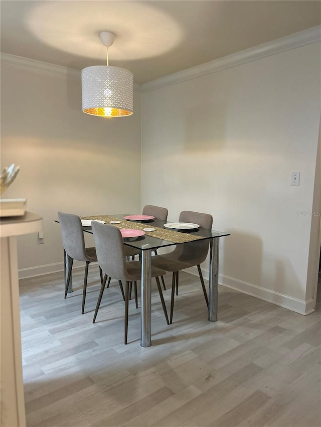 dining room featuring wood-type flooring and ornamental molding