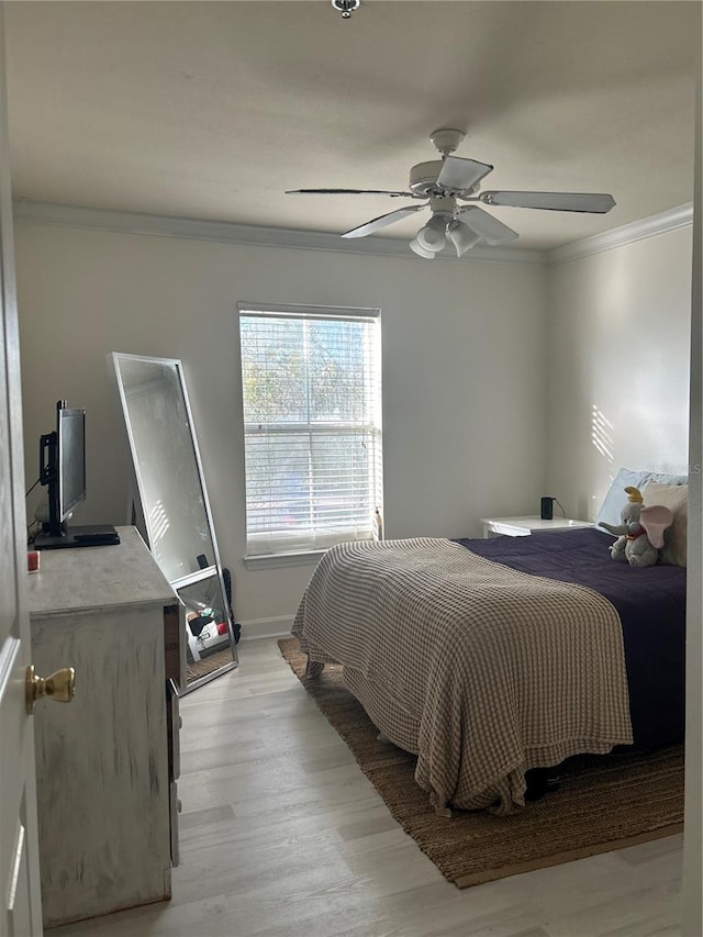 bedroom with ceiling fan, light wood-type flooring, and crown molding