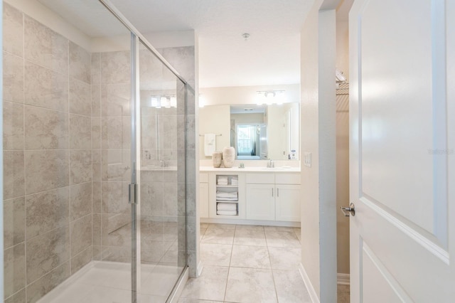 bathroom featuring tile floors, a shower with shower door, and vanity