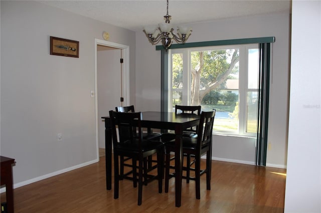 dining area featuring a textured ceiling, plenty of natural light, dark wood-type flooring, and a chandelier