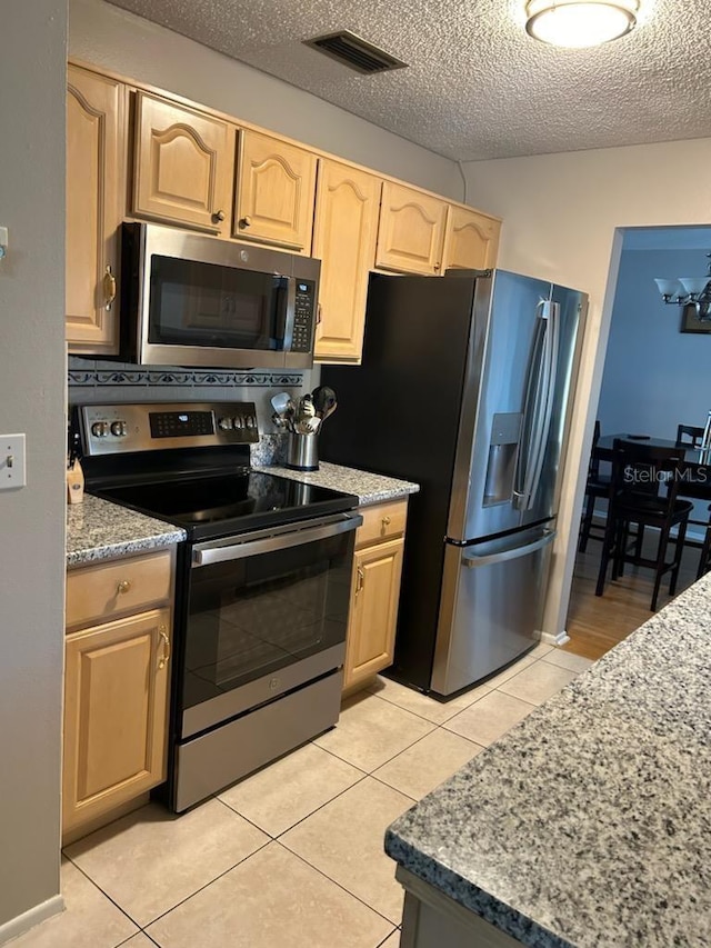 kitchen featuring appliances with stainless steel finishes, light tile patterned floors, and light brown cabinetry