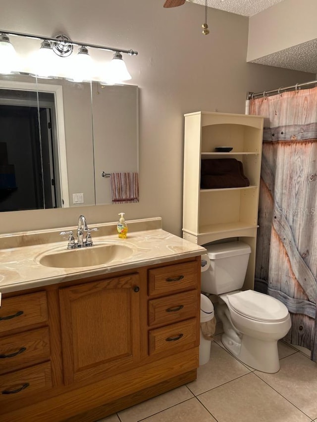 bathroom featuring vanity, a textured ceiling, ceiling fan, tile patterned flooring, and toilet