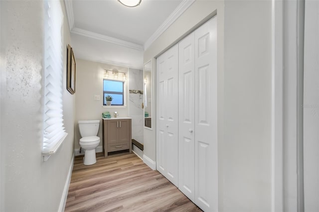 bathroom with vanity, crown molding, hardwood / wood-style floors, and toilet