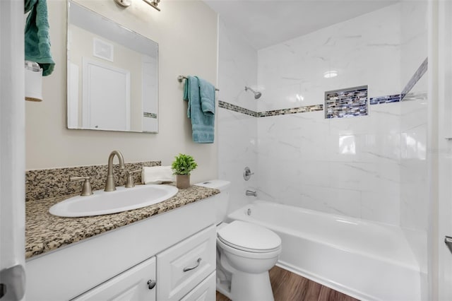 full bathroom with tiled shower / bath combo, wood-type flooring, toilet, and large vanity