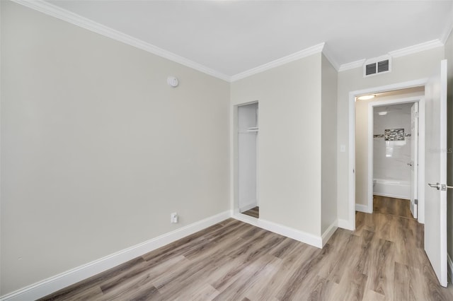 unfurnished bedroom with ornamental molding, a closet, and light hardwood / wood-style flooring