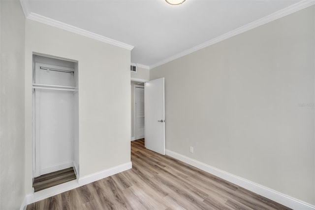 unfurnished bedroom featuring crown molding, a closet, and light hardwood / wood-style flooring