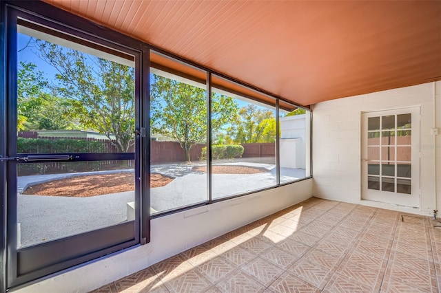 unfurnished sunroom with wooden ceiling and a wealth of natural light