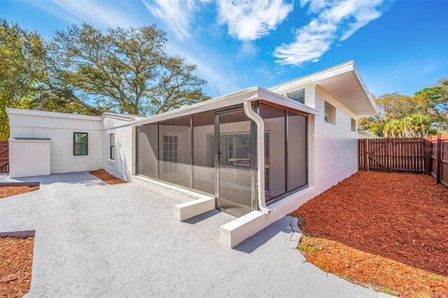 rear view of property with a patio and a sunroom